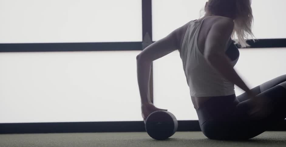 Woman uses a bolster to do sit-ups