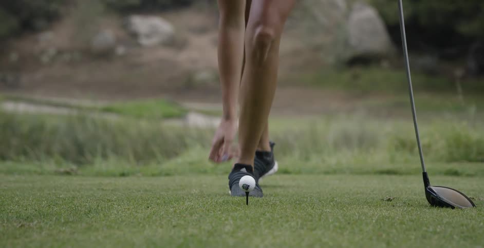 A woman golfs on a golf course