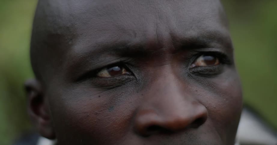 An african man is staring ahead thinking outside during the day