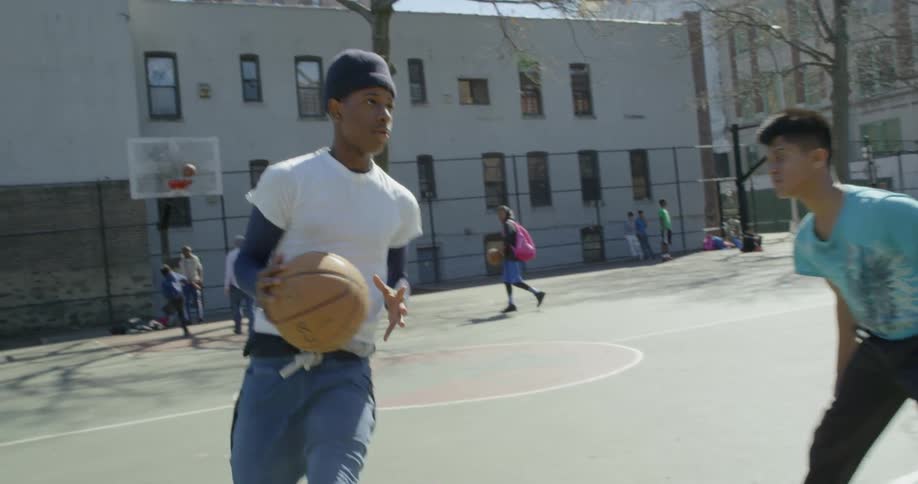 Kids are playing basketball on a sunny day