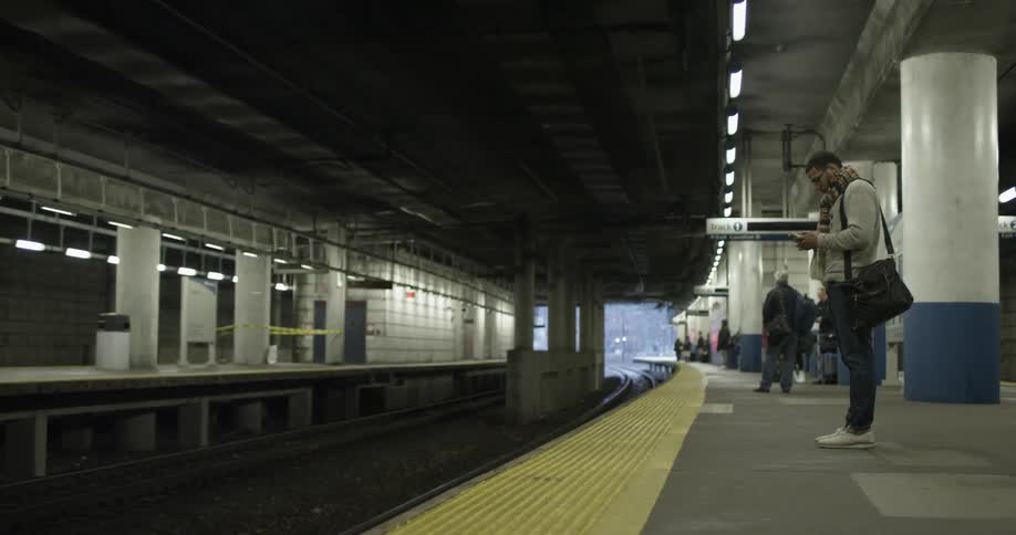 Man stands on a platform in a subway