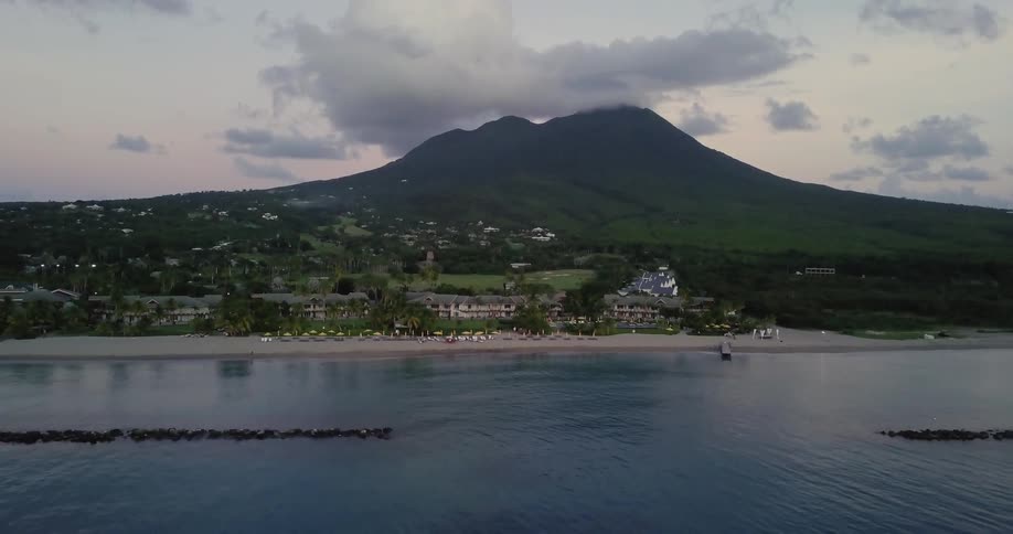 A beach side resort with a large mountain in the background