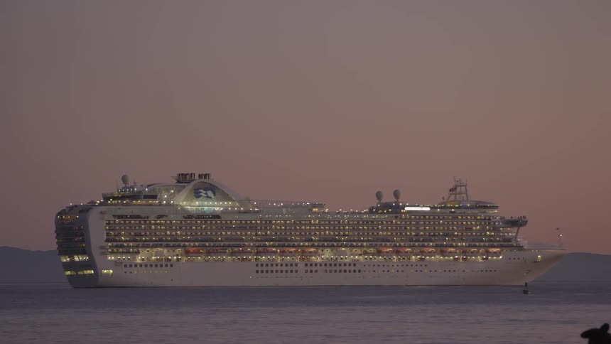 Full view of a very large cruise ship sitting in the water