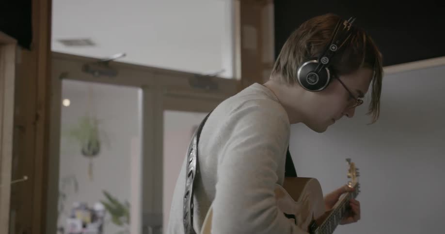 Man playing a guitar nods his head