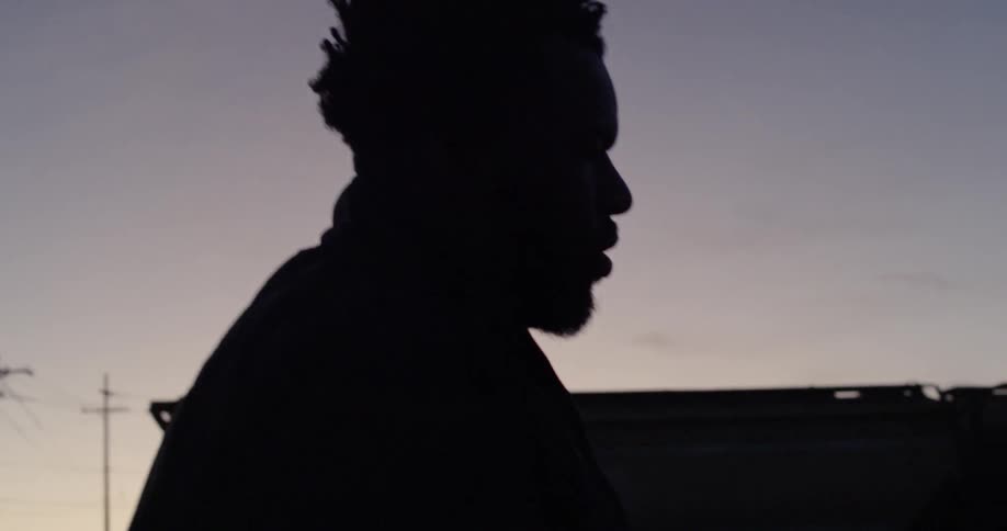 A man walks outside at dusk