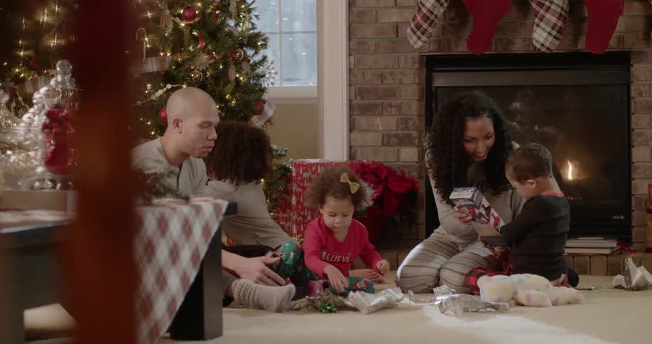A family sits next to a christmas tree