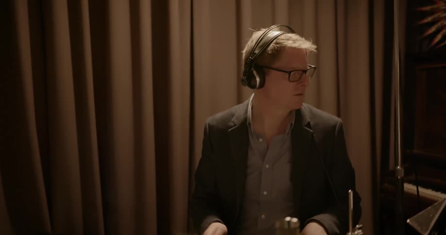 A drummer is playing the drums in a recording studio