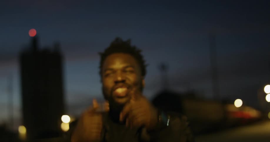 A man laughs and talks outside at night