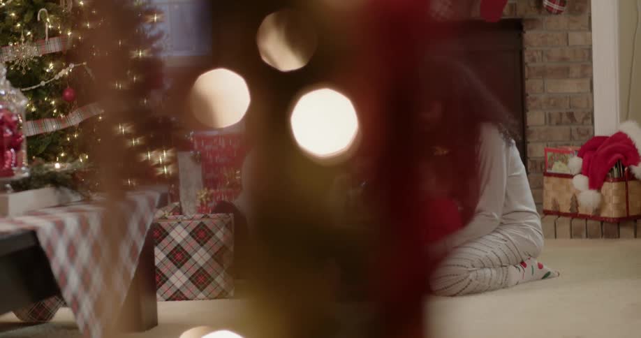 A family celebrate christmas while sitting on the floor