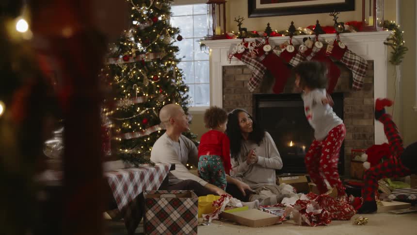 A family sits next to a christmas tree