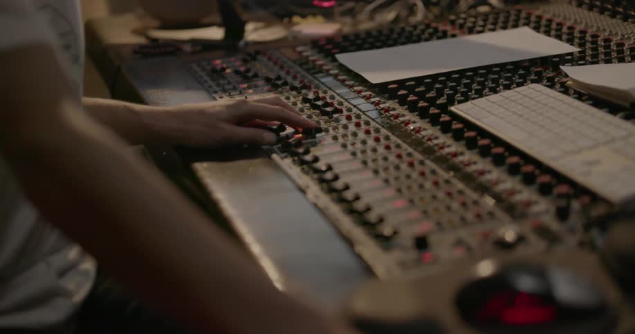 A man adjusts knobs on a mixer
