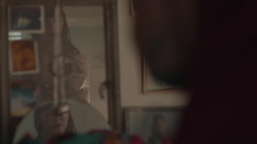 Woman stares into mirror and thinks