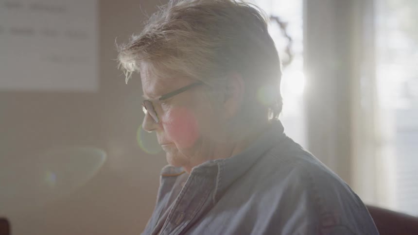 Elderly woman sits and concentrates on something