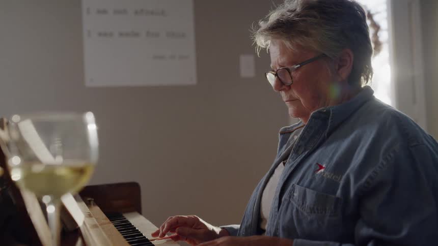 Someone is playing piano with a glass of wine sitting on top of it