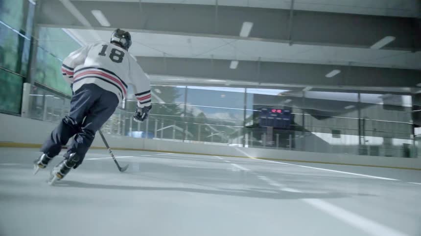 A hockey player ice skates on an indoor rink