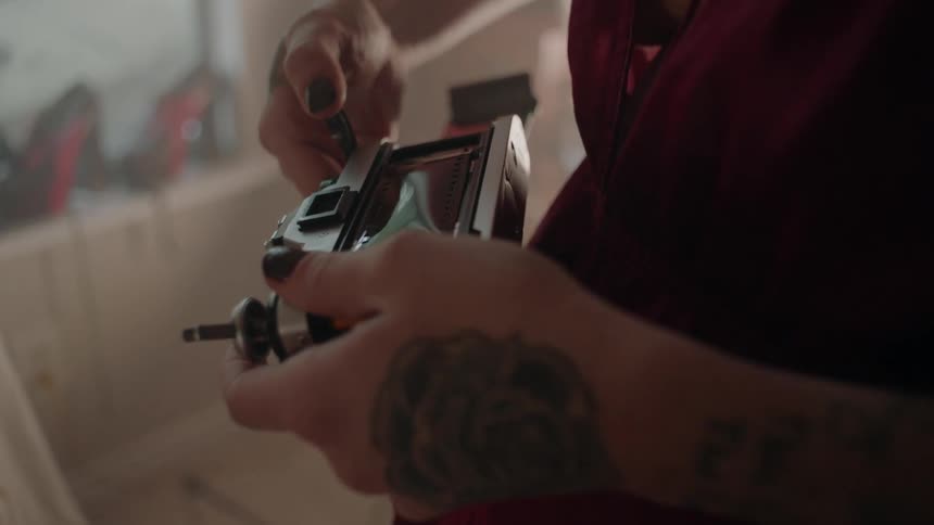 A woman closes a camera after loading film