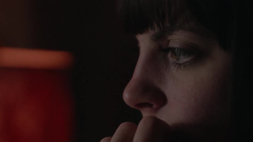 Woman stares and chews on fingernails