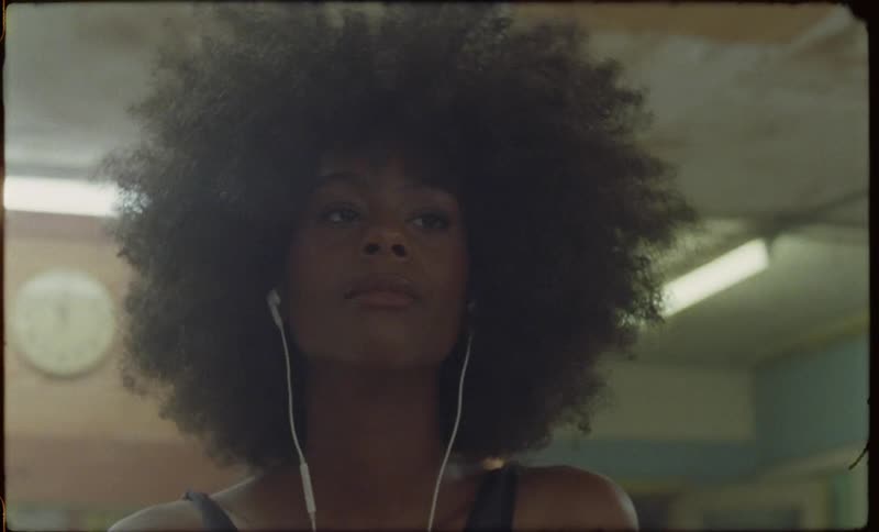 A woman is bobbing her head as she listens to music while inside