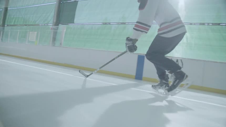 A hockey player skates on an indoor ice rink