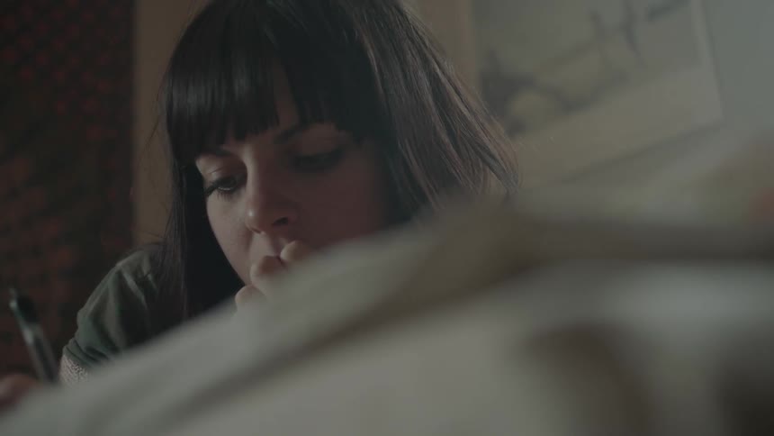 A woman is writing something down with an ink pen