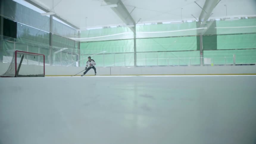 A player at an ice rink takes a shot on goal and scores