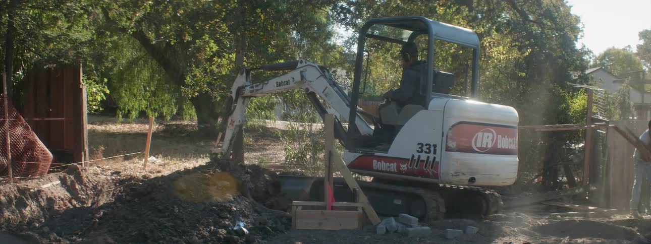 A construction worker operates a digger at a work site