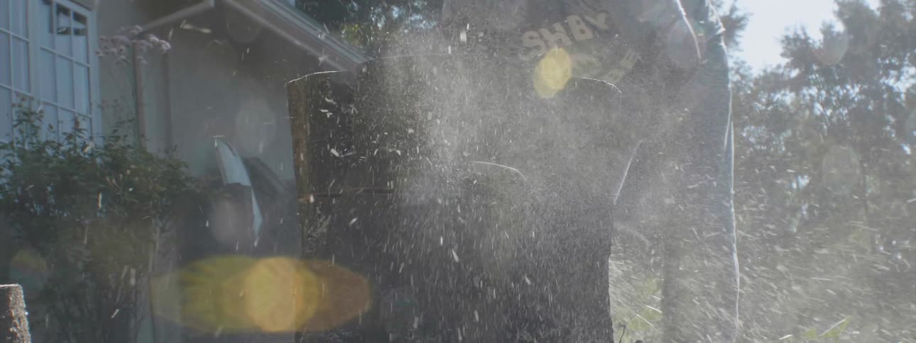 A man cuts a tree trunk with a chainsaw