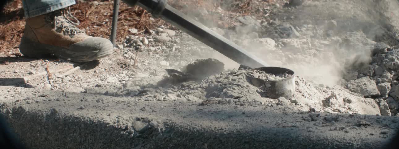 A construction user breaks up concrete with a jackhammer