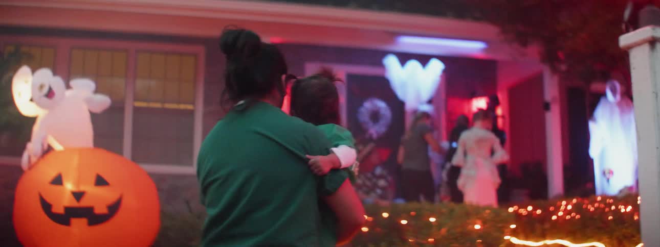 Children are trick or treating as parents watch and walk with them