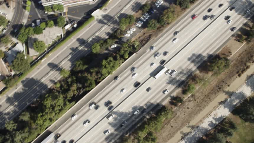Vehicles are driving on a freeway during the day