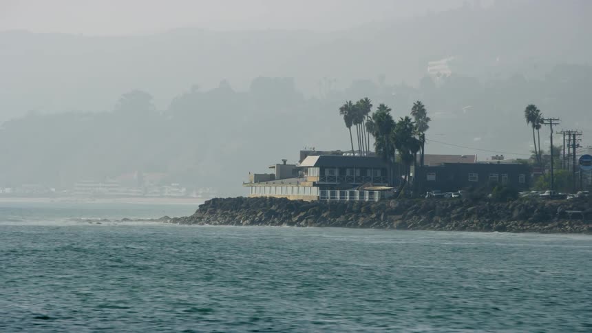 Buildings sit on an ocean shoreline
