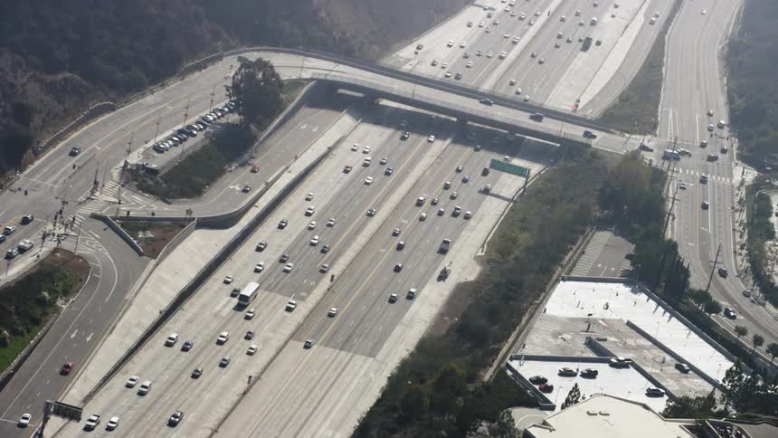 Cars traveling down a highway on a sunny day