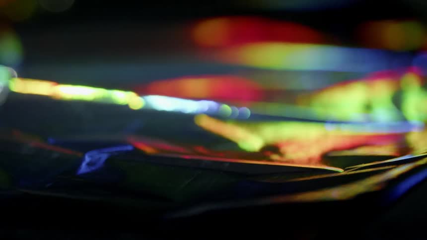 Rainbow lights reflect on a still surface