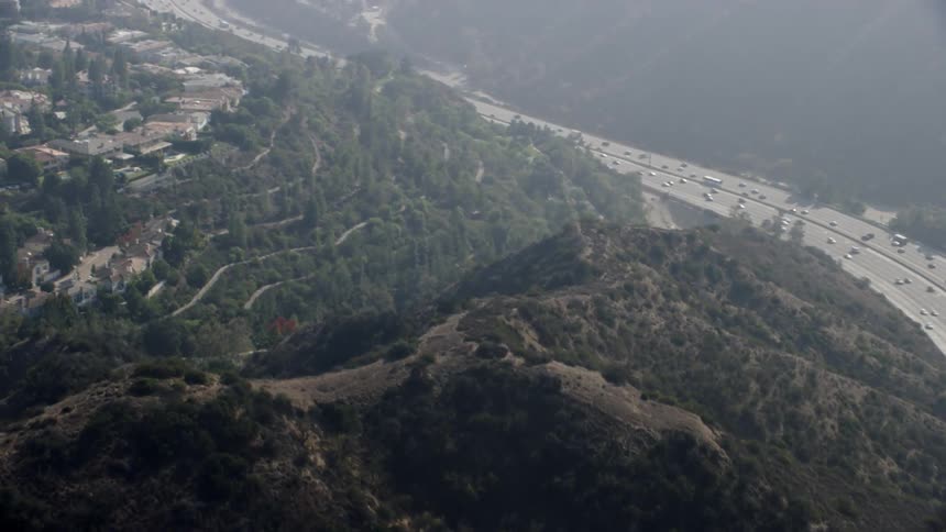 A busy interstate with large hills surrounding it
