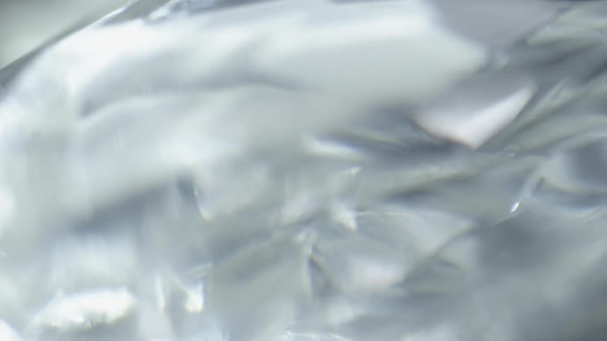 Light and shadow move across a reflective surface