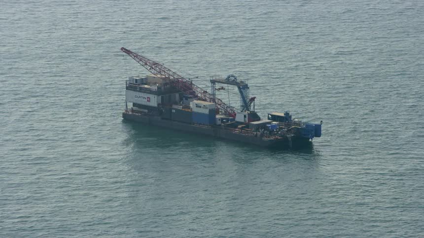 The cargo ship is traveling in the water