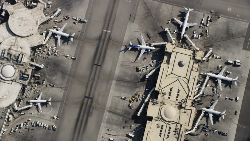 There are many vehicles and planes parked in the airport