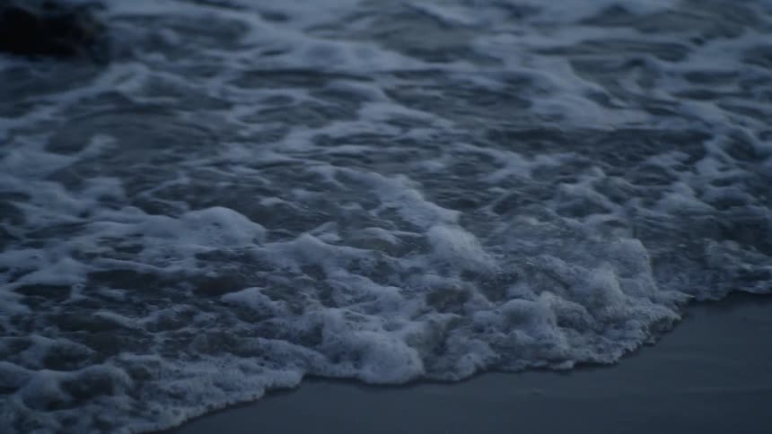 Ocean waves wash ashore a sandy beach