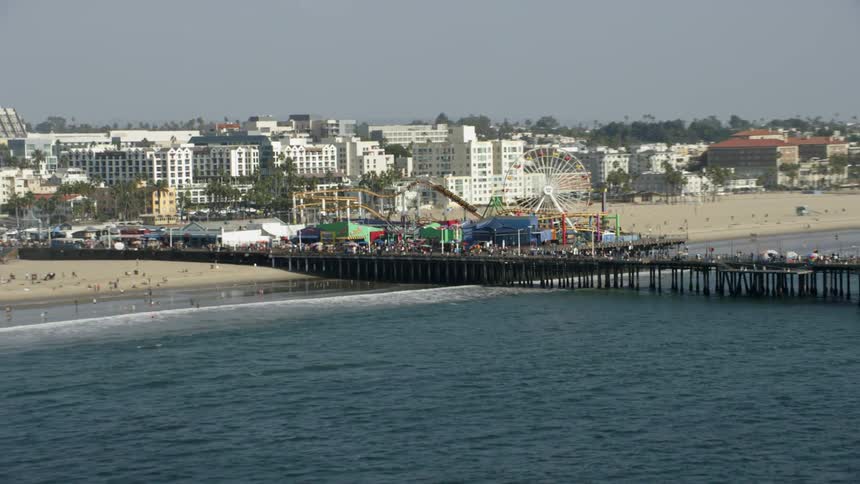 Amusement rides on a pier at a beach on a clear day