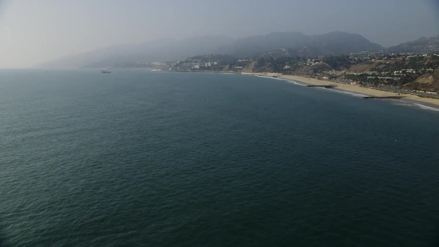 Fog rolls over the hills by the shore