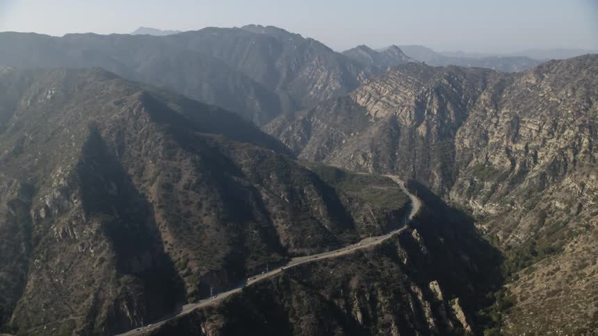 Cars drive around the road snaking around the mountain