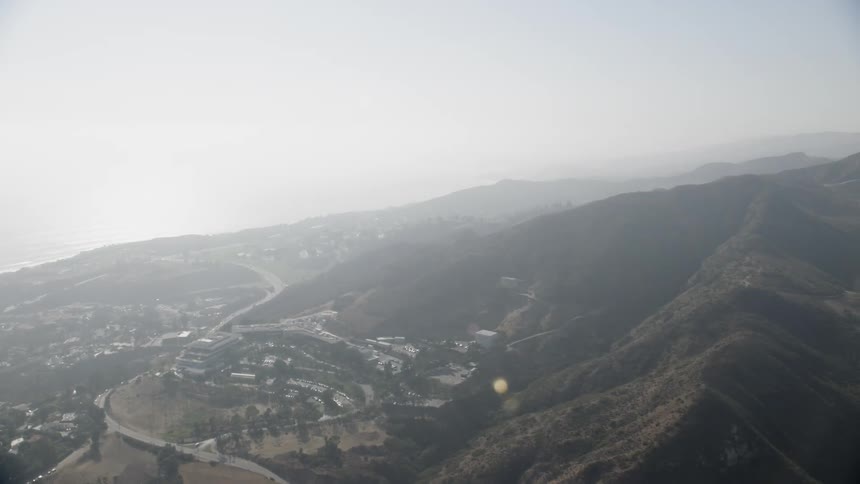 Sunlight shines over hillside buildings