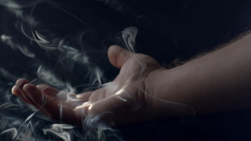 Smoke floats around an outstretched hand
