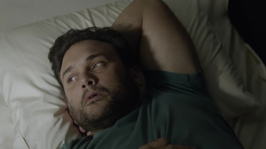A man is thinking as he lies in bed in the morning