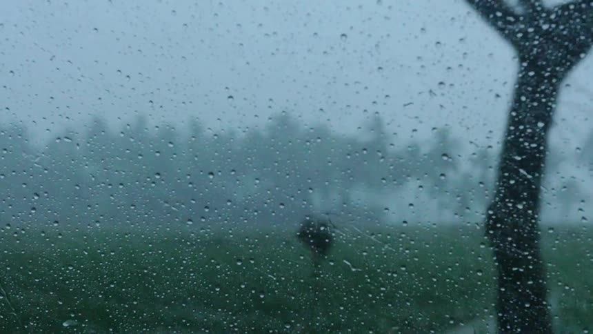 Rain splashes on a traveling car's window