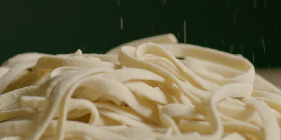Long flat noodles fall into a pile
