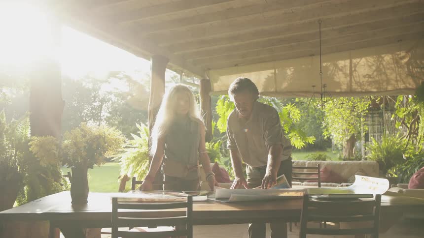 Two people look at some papers on a table