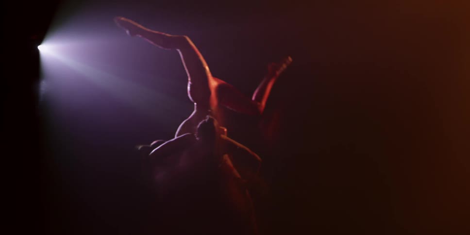 Two female acrobats are performing a balancing move