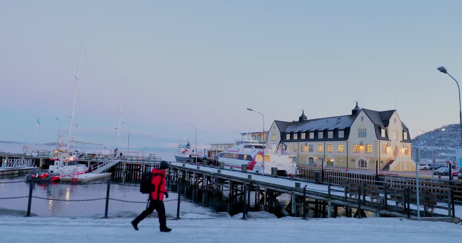Man walks on a pier wearing a backpack