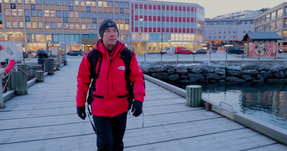 A man walks on a snowy dock